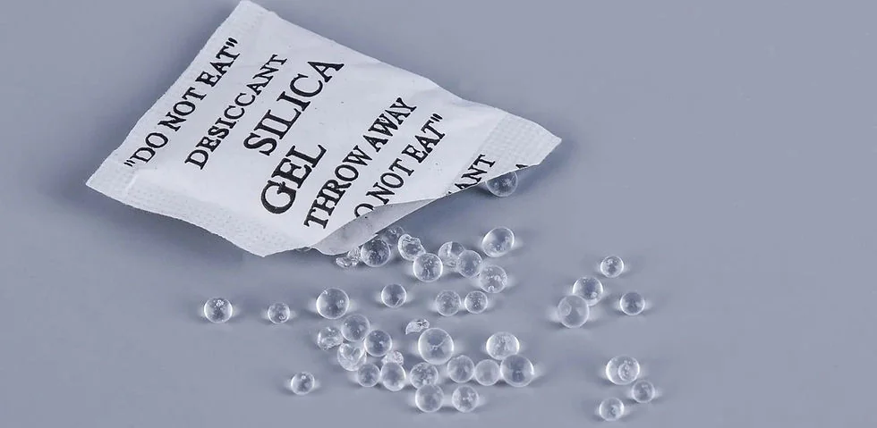 Silica gel sachet with beads spilled beside it